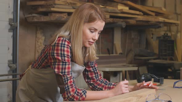 Beautiful Carpenter Woman Making Marks on Wooden Piece