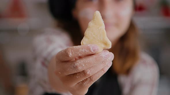 Selective Focus of Child Holding Cookie Dough with Tree Shape in Hands