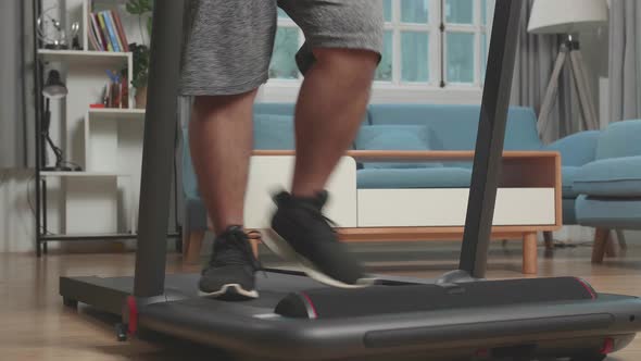 Legs Of Asian Fat Man Wearing No T-Shirt And Training On Walking Treadmill At Home