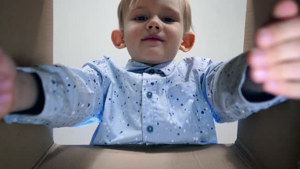 Little Boy Opens a Parcel Box of Emotions and Being Surprised