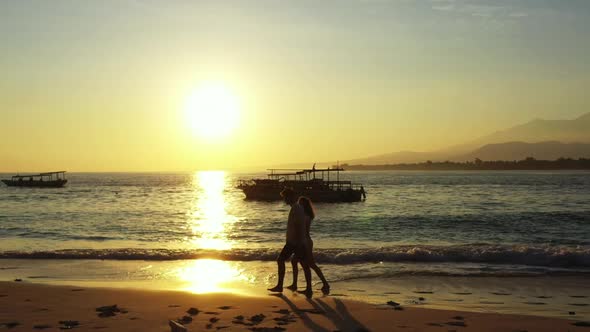 Man and woman sunbathe on perfect coast beach holiday by blue ocean with white sandy background of B