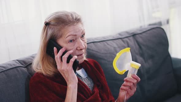 Lonely Senior Woman Holding Oxygen Inhaler and Having Phone Conversaion