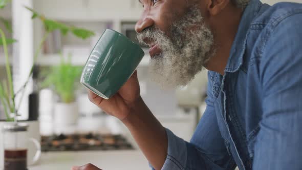 Video of african happy american senior man drinking coffee
