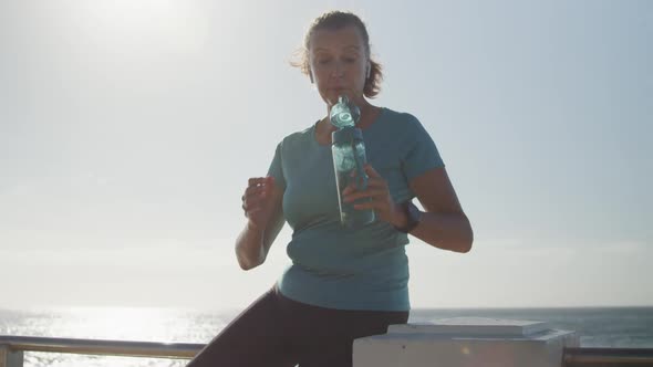 Senior woman drinking water on a promenade