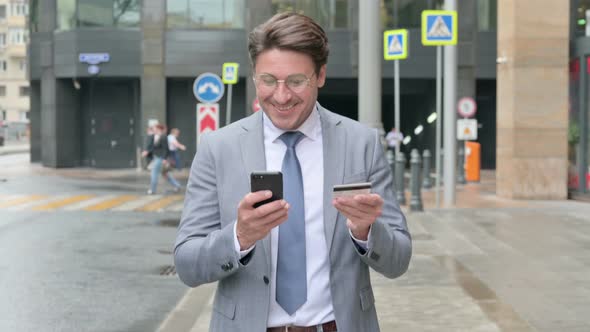 Walking Businessman Shopping Online on Smartphone