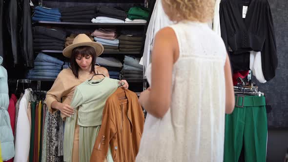 Two Cheerful Girlfriends are Shopping in a Clothing Store