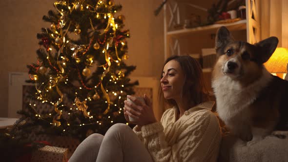 Slow Motion Broll Happy Girl in White Knitted Sweater Drinks Hot Chocolate and Relaxing Sitting on