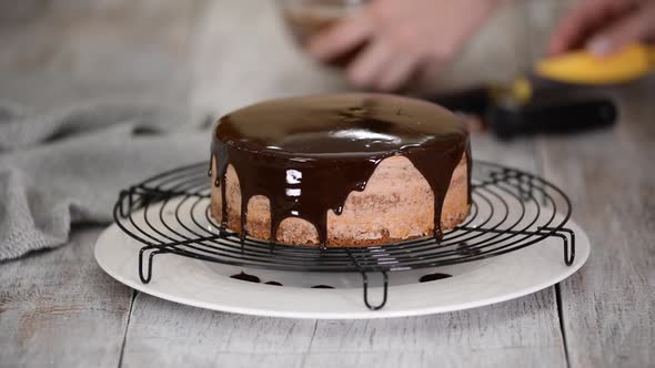 Glazing Chocolate Cake with Melted Chocolate. Woman Pouring Chocolate Over Cake
