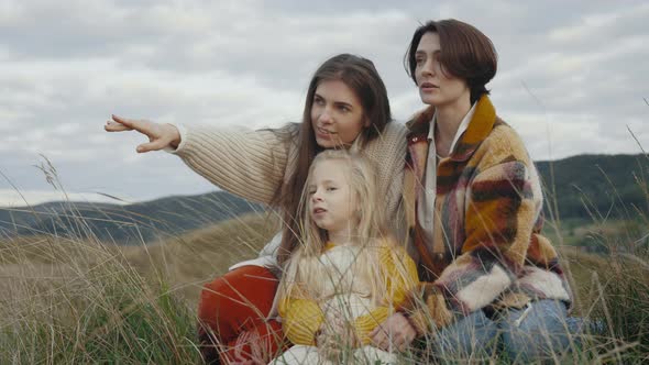 Two Lesbians Resting with Little Daughter on Nature