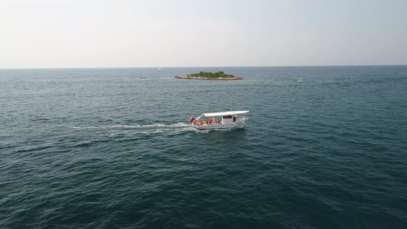 Small Boat with passengers sailing near tiny island in Adriatic Sea, Croatia