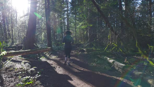 Caucasian Woman Trail Running in the Green Forest