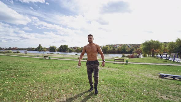 Shirtless male exercise outdoors. Muscular athlete exercising push up outside