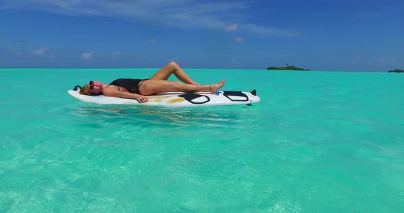 Beautiful fun women on vacation in the sun on the beach on sunny blue and white sand 4K background