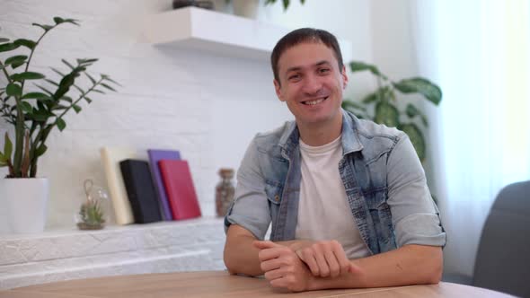 Head Shot Millennial Guy Sit in Living Room Makes Video Call Looks at Camera Conversation