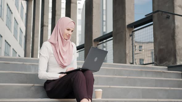 Portrait of Attractive Arabian Woman in Elegant Clothes and Hijab Sitting on