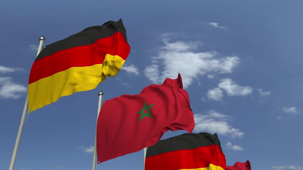 Waving Flags of Morocco and Germany on Sky Background