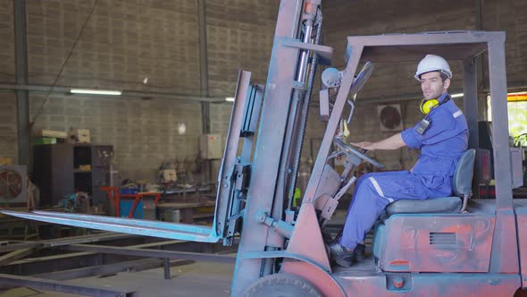 Concentrated forklift caucasian driver operating machine and holding hand on steering wheel