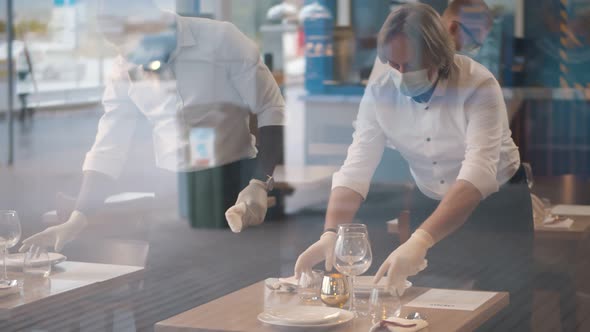 Waiters in Medical Protective Mask Serving Table in Restaurant.