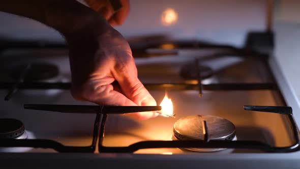 Lack of gas. A man is trying to light a match with gas on a gas stove