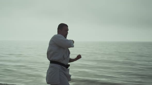 Karate Fighter Making Dynamic Hands Punches on Sunset