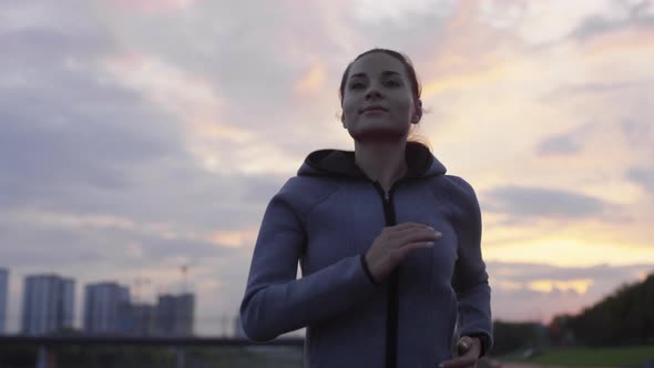 Young Beautiful Woman Jogging Outdoors in Evening