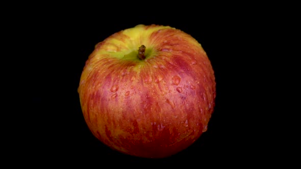 Water Is Sprayed on a Red Apple. On a Black Isolated Background