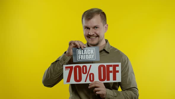 Shocked Amazed Store Client. Man Showing Black Friday and Up To 70 Percent Off Inscriptions Signs