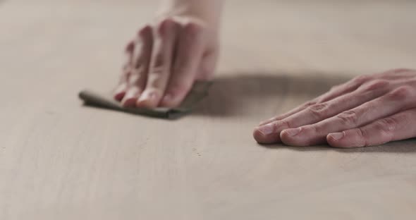 Slow Motion Slide Orbit Shot of Man Hand Sanding Black Walnut Wood Table