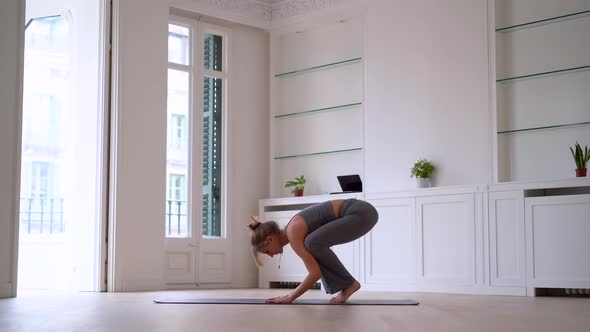 Woman doing yoga on mat in spacious room