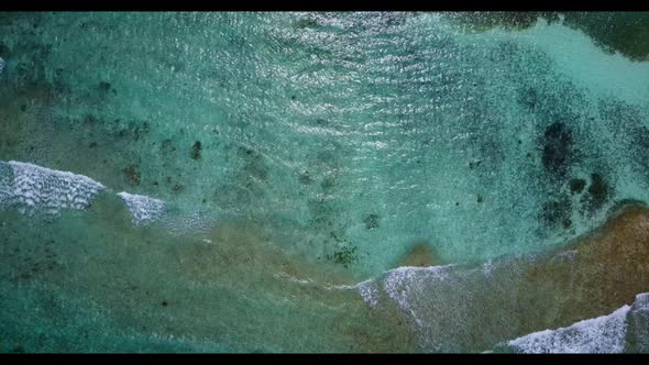 Aerial drone shot scenery of marine shore beach lifestyle by blue green sea and white sand backgroun