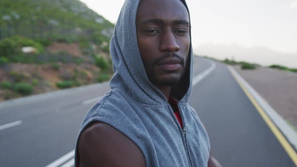 Portrait of african american man wearing a hoodie standing on the road