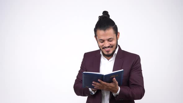 Happy Indian businessman reading sales report and smiling