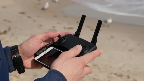 Remote control of the drone in the close-up. Men controlling flying drone for aerial view.