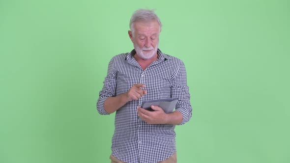 Happy Senior Bearded Man Using Digital Tablet