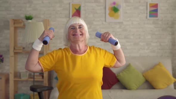 Senior Fitness Old Woman Posing with Dumbbells and Looking at Camera Smiling