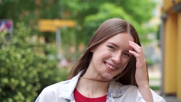 Girl walking down the street looks at the camera