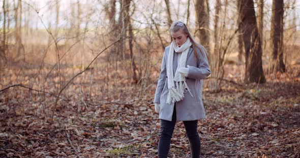 Portrait of Positive Female Walking in Woods in Autumn