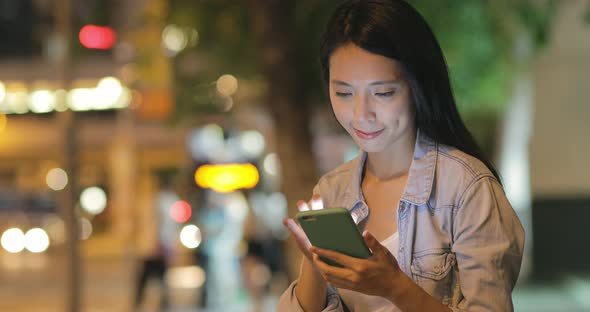 Woman using mobile phone at night 