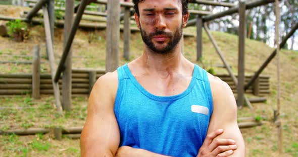 Fit man standing with arms crossed in boot camp 4k