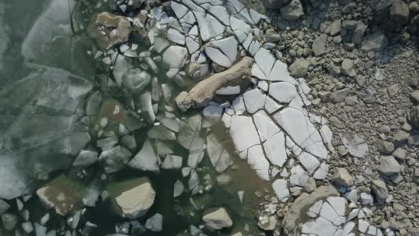 Rising Overhead Shot of Large Chunks of Ice at the Shoreline of a Lake in Norway