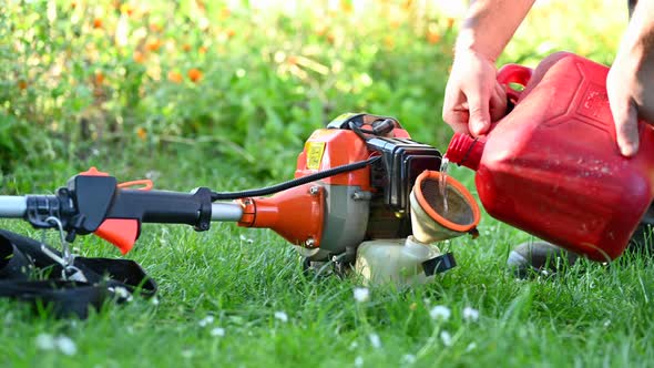 Gardener Refueling Brush Cutter Close Up. Gardening Tools Maintenance. Lawn Care with Brush Cutters.