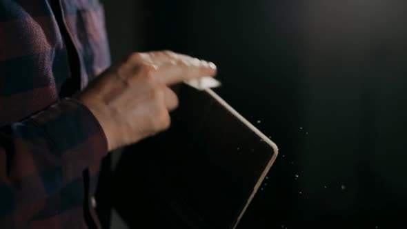 The Process of Manufacturing a Leather Wallet Handmade. The Craftsman Grinds the Finished Product