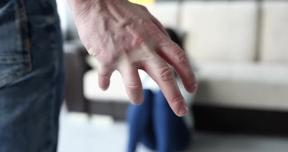 Man Fist Clenches in Rage Against the Backdrop of Frightened Woman