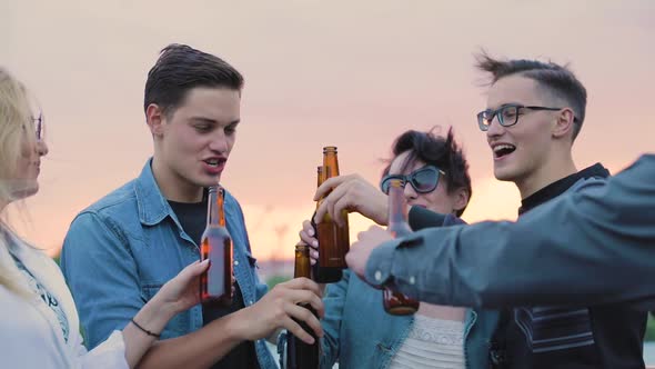 Happy Friends Drinking Beer, Cheering With Bottles And Dancing