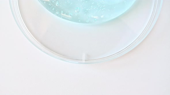 Blue Transparent Cosmetic Gel Cream With Molecule Bubbles Flowing On The Plain White Surface