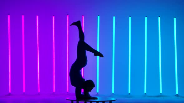 Sportswoman Performs Gymnastics Against the Backdrop of Neon Lights