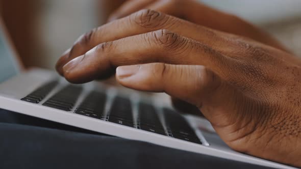 Male African American Man Hands Typing on Laptop Keyboard Close Up