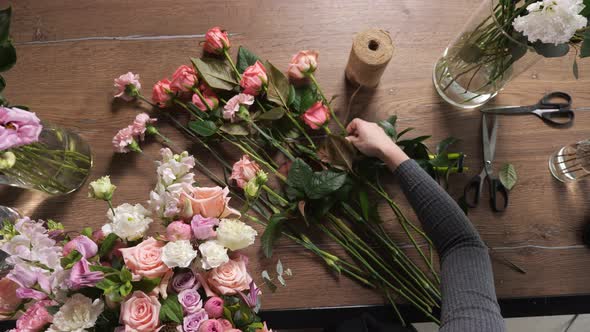 Florist Woman Composes Wedding Bouquet with Colorful Roses