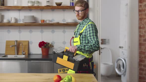 Professional Repairman Walking in Kitchen with Toolbox