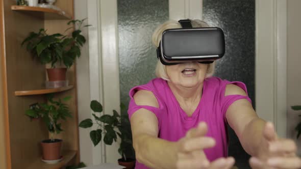 Senior Grandmother Woman in Virtual Headset Glasses Watching 3d Video in 360 Vr Helmet at Home